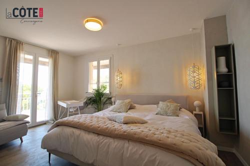 Un dormitorio con una cama grande y una ventana. en A couper le souffle Magnifique Villa sur l'eau, en La Redonne