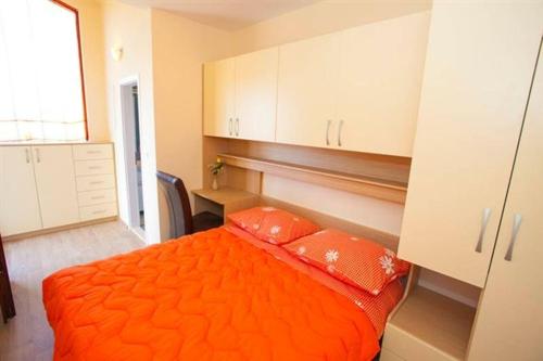 een slaapkamer met een oranje bed en 2 oranje kussens bij Apartments with a parking space Makarska - 11418 in Makarska
