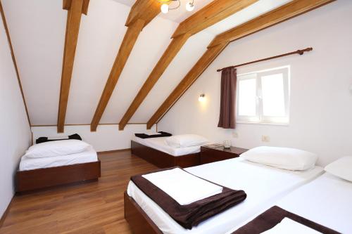 2 letti in una camera con travi in legno di Holiday Home Kanica 10367 a Rogoznica (Rogosnizza)