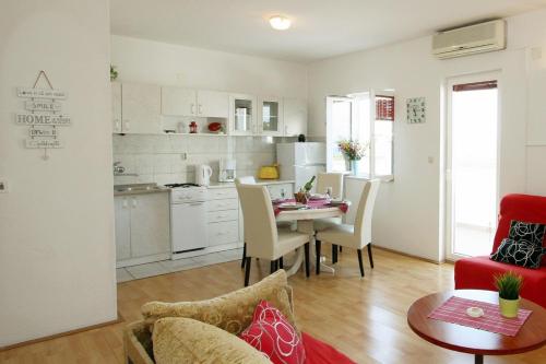 Il comprend une cuisine et un salon avec une table et des chaises. dans l'établissement Apartments with a parking space Supetar, Brac - 11147, à Supetar