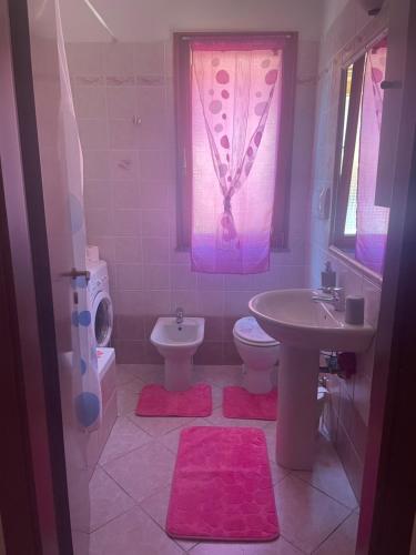 a bathroom with a sink and a toilet and a window at Da.Da. House in La Maddalena