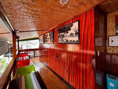 a room with a red wall with a picture on it at Balay Paragua in El Nido