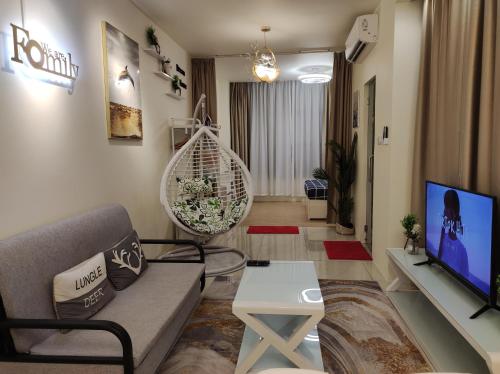 uma sala de estar com um sofá e uma televisão em Thirteen Residence [TR06] @ ITCC Manhattan Suites em Kota Kinabalu