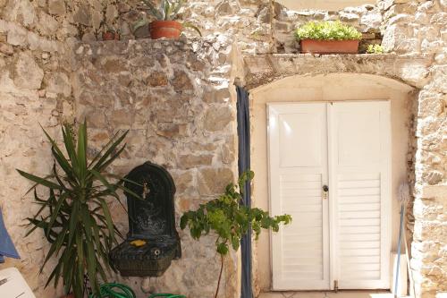 a stone building with a white door and a plant at Rooms by the sea Makarska - 11096 in Makarska