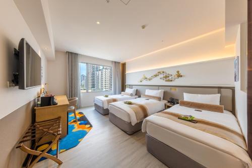 ein Hotelzimmer mit zwei Betten und einem Fernseher in der Unterkunft Taipei Garden Hotel - Ximending in Taipeh