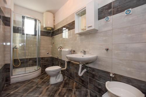 a bathroom with a toilet and a sink and a shower at Apartments with parking space Pag - 11358 in Pag