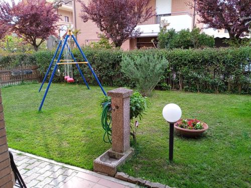 ペーザロにあるil Gelsomino appartamento turisticoのブランコ付きの庭遊び場