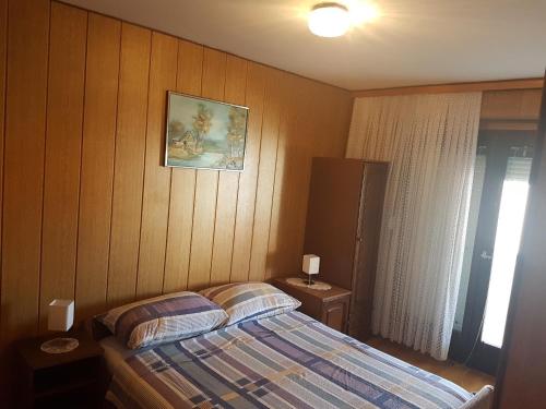 a bedroom with a bed and a picture on the wall at Apartments for families with children Lopar, Rab - 10402 in Lopar