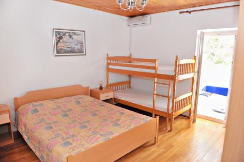 a bedroom with a bed and a bunk bed and a ladder at Apartments by the sea Metajna, Pag - 10405 in Zubovići