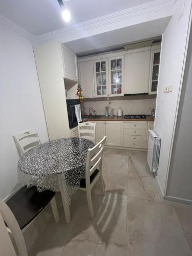 una cucina con tavolo e sedie in una cucina di luxe apartment a Batumi
