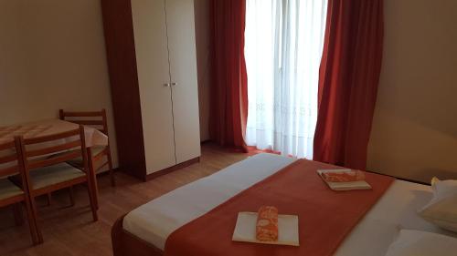 a bedroom with a bed and a table and a window at Apartment Gradac 11332d in Gradac