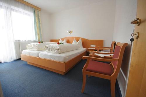ein Schlafzimmer mit einem großen Bett und einem Stuhl in der Unterkunft Haus Hanser in Zellberg