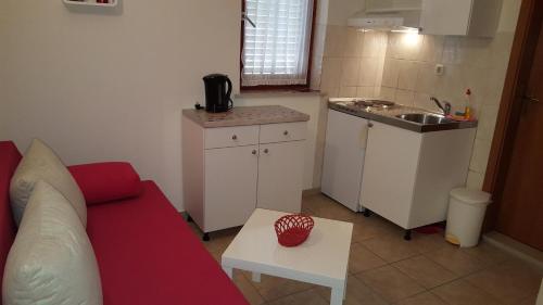 a living room with a red couch and a kitchen at Apartment Gradac 11332d in Gradac