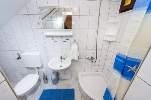 a white bathroom with a toilet and a sink at Apartments with a parking space Nin, Zadar - 10414 in Nin