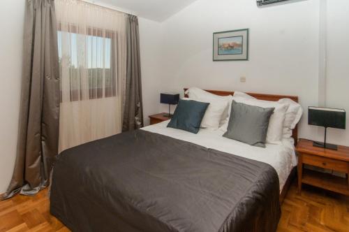 Un dormitorio con una cama grande y una ventana en Apartment Mali Losinj 10420b en Mali Lošinj