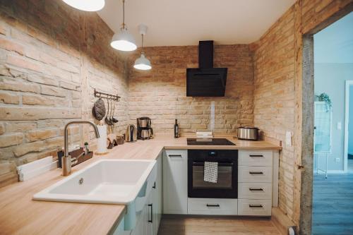 eine Küche mit einem weißen Waschbecken und einer Ziegelwand in der Unterkunft Stadthytte Ferienhaus in Rostock