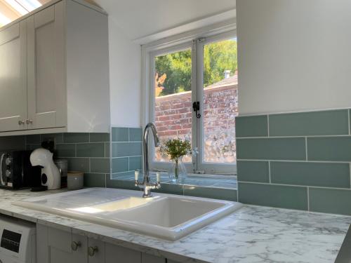 a kitchen with a sink and a window at Charming Cottage mins from Chichester City Centre in Chichester