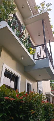 a building with a balcony with plants on it at Layang Layang Home in El Nido