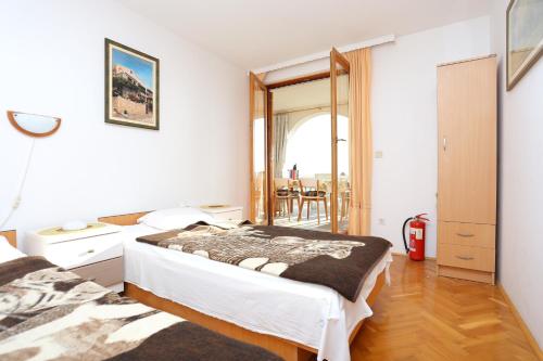 グラダツにあるApartments with a parking space Gradac, Makarska - 6825のベッド2台と鏡のある寝室