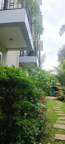 a building with a balcony and some green bushes at Layang Layang Home in El Nido