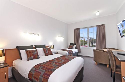 a hotel room with two beds and a desk at William Dutton Motel in Portland