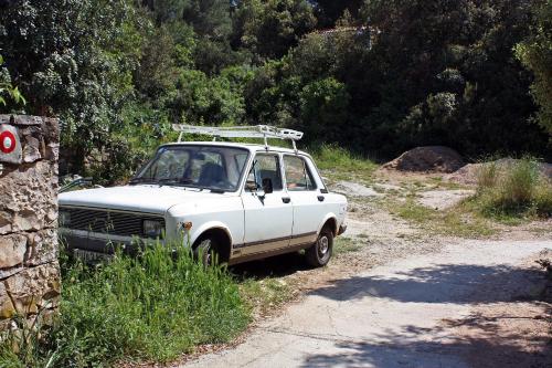 a white car parked on the side of a dirt road at Apartment Pomena 10426b in Goveđari