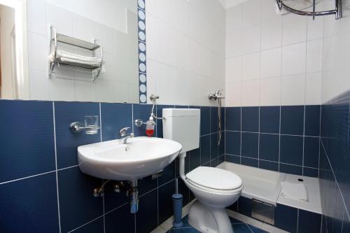 baño azul y blanco con aseo y lavamanos en Apartment Pomena 10426b, en Goveđari