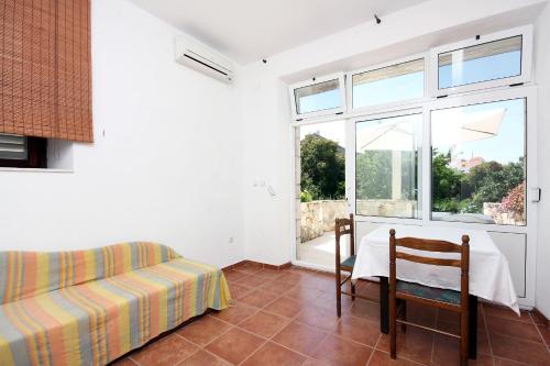1 dormitorio con 1 cama, 1 silla y 1 ventana en Apartment Pomena 10426b, en Goveđari