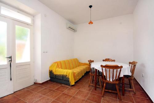ein Esszimmer mit einem Tisch und einer gelben Decke in der Unterkunft Apartments by the sea Pomena, Mljet - 10426 in Goveđari