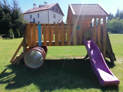 a wooden playground with a slide and a gazebo at Kasztanowe Wrota in Kosewo