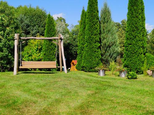 a park with a wooden bench in the grass at Kasztanowe Wrota in Kosewo