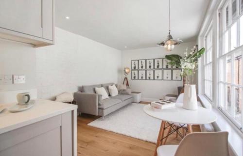 a white living room with a couch and a table at Turnagain Lane, Canterbury City Centre in Canterbury