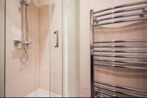 La salle de bains est pourvue d'une douche avec une porte en verre. dans l'établissement Turnagain Lane, Canterbury City Centre, à Canterbury