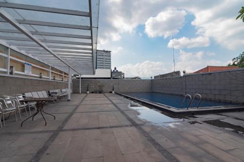 a patio with a swimming pool on top of a building at Urbanview Hotel Newton Riau Bandung by RedDoorz in Bandung