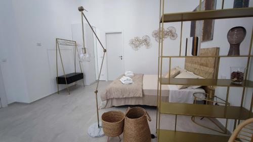 a room with a bed and a shelf with baskets at Dimore Gilas - Suite Golden in Monopoli