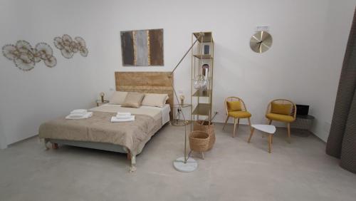 a bedroom with a bed and chairs in a room at Dimore Gilas - Suite Golden in Monopoli