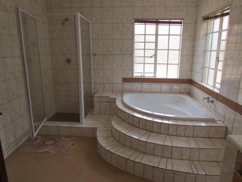 uma grande casa de banho com banheira e chuveiro em Lalamnandzi2 em White River