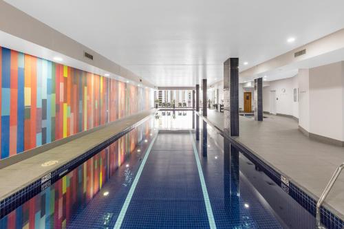 a swimming pool with colorful walls in a building at Meriton Suites Campbell Street, Sydney in Sydney
