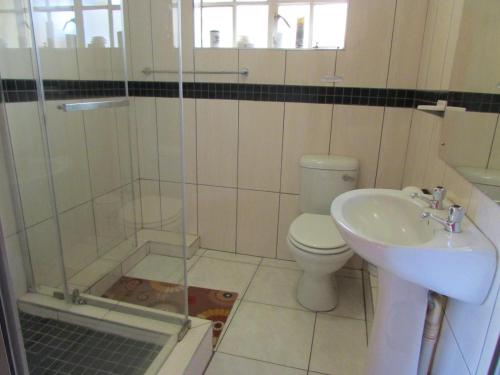 a bathroom with a shower and a toilet and a sink at Lalamnandzi2 in White River