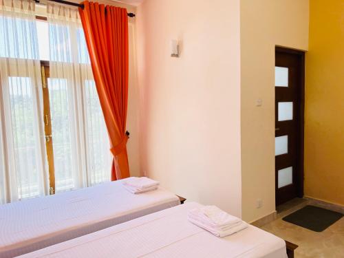 Duas camas num quarto com um espelho e uma janela em Hansons Homestay em Kandy