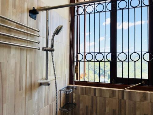 a shower in a bathroom with a window at Hansons Homestay in Kandy