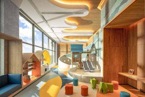 a childrens room with colourful chairs and a slide at Citadines Marina Halong in Ha Long