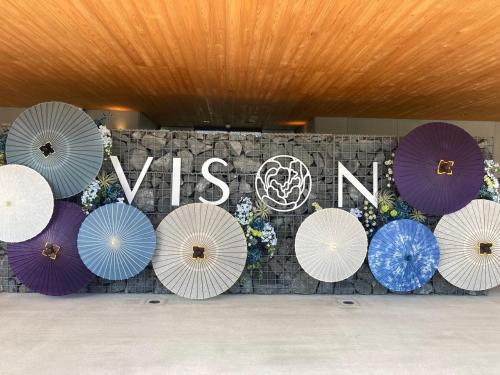 a bunch of umbrellas in front of a wall with a sign at Hotel Vison in Taki