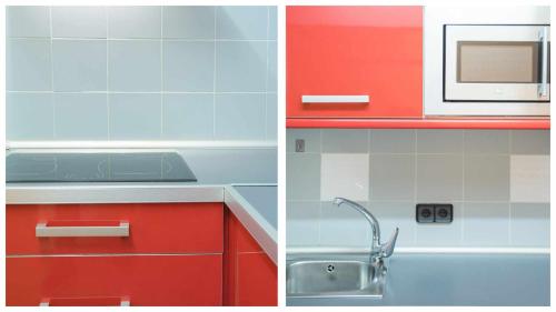 a kitchen with red cabinets and a microwave at The Magic Place Dúplex junto a la Catedral by Toledo AP in Toledo