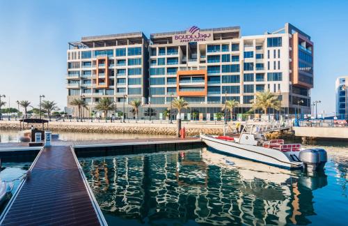 a boat docked in the water in front of a building at Boudl Al Jubail in Al Jubail
