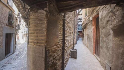 an alley in an old building with a brick wall at The Magic Place Dúplex junto a la Catedral by Toledo AP in Toledo