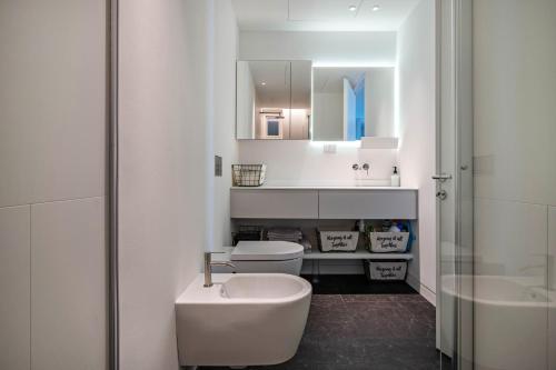 Baño blanco con lavabo y aseo en Luxury Apartment Jesolo, en Lido di Jesolo