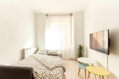 1 Schlafzimmer mit einem Bett, 2 Stühlen und einem Tisch in der Unterkunft Apartamento Ayla San Fermín in Pamplona