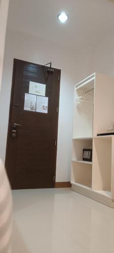 a brown door in a room with an open refrigerator at Layang Layang Home in El Nido