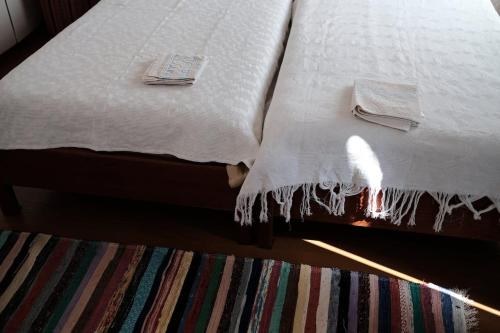 a bed with white sheets and towels on it at Ikaria - Evdilos village , Katsirifos in Évdhilos